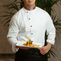 cook holds sliced rolls on plate