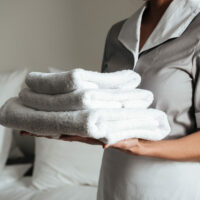 Cropped image of a young hotel maid standing and holding fresh clean towels